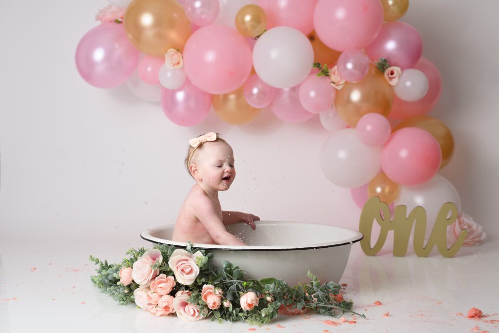 cake smash bath pink flowers gold balloons one year old